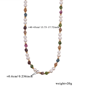 Close-up of colorful tourmaline beads and pearls with gold spacers and lobster clasp
