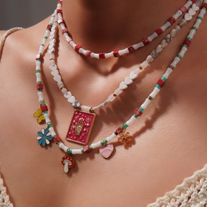 Collier bohème à trois rangs avec perles et pendentifs cœur, papillon et champignon sur mannequin