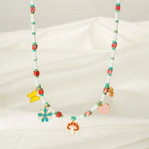 Collier de perles multicouche avec pendentifs papillon et fleur sur tissu blanc plissé
