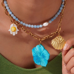 Double-layered gold chain necklace with blue beads, Fatima hand, and scallop charms