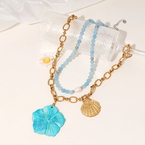Gold-tone chunky chain with shell and flower charms paired with light blue beaded necklace