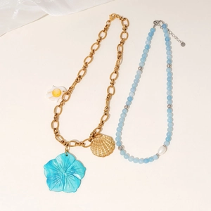 Gold chain necklace with blue flower and shell pendants paired with blue beaded pearl strand