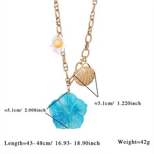Detailed view of flower and shell pendants on a stainless steel necklace with size info