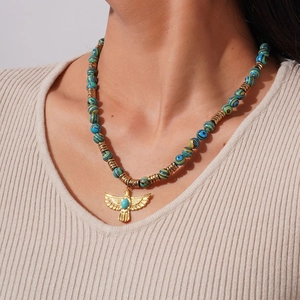 Collier perles bohème avec pierres turquoise et pendentif aigle doré porté