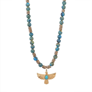 Collier ethnique avec perles et pendentif aigle doré serti d'une turquoise sur fond blanc