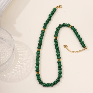 Détails des perles de malachite verte et pendentif en acier sur un collier à étages