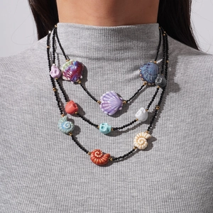 Collier fait main avec perles de spinelle noire, coquillages et pendentifs crânes colorés