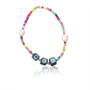 Detail of bohemian colorful seed bead bracelet with pearls and blue evil eye square beads