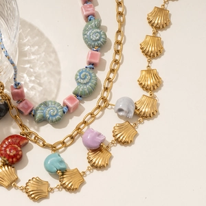 Beaded shell and skull necklace featuring nautical nautilus charms and gold metal accents