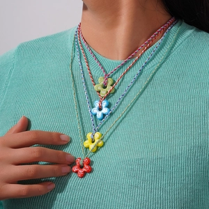 Ensemble de quatre colliers fleurs en verre coloré avec motifs marbrés sur cordes