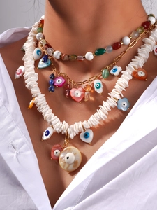 Close-up of layered bohemian necklace with natural stone beads and evil eye charms