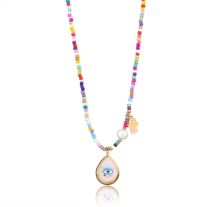 Detail of colorful beads with Hamsa hand and Evil Eye pendants on a boho style necklace