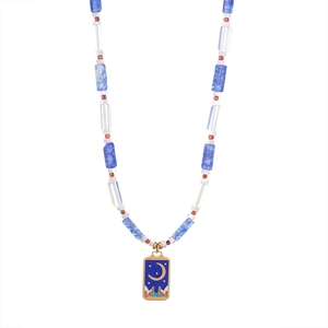 Detail van kralenketting met gekleurde stenen en gouden tarot maan en ster hanger