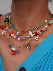 Detail van gelaagde kerstketting met kleurrijke kralen en hangers van de kerstman