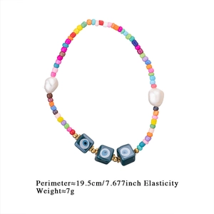 Detail of bohemian rainbow bead bracelet with evil eye charms and white pearls
