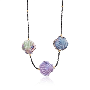 Détail du collier de perles noires avec pendentifs en coquillage et perles dorées