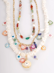 Detail of bohemian necklace set with natural stones and shell evil eye pendants
