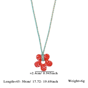 Macro d'un pendentif fleur en verre rouge de 2,4cm avec motif rayé sur cordon tissé