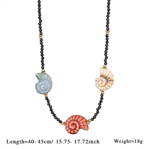 Détail d'un collier de perles fait main avec spinelle noir et pendentifs coquillages