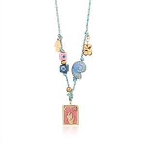 Macro detail of Hamsa Hand and Evil Eye pendants on a blue bohemian beaded necklace