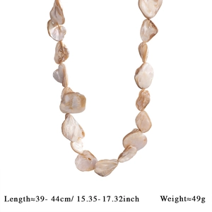 Close-up of baroque pearls on stainless steel Figaro chain beach necklace