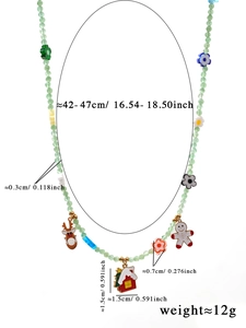 Detail van kerstketting met kralen en bedeltjes zoals rendier en een gemberkoekje