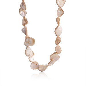 Detailed close-up of natural shell slices with brown textures on a Figaro chain necklace