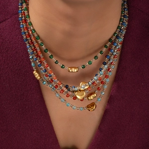 Détail d'un collier de perles multicouches avec pierres colorées et breloques cœur