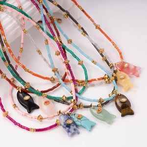 Stack of colorful beaded necklaces with fish stone pendants and gold stainless steel accents