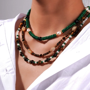 Mehrlagige Kette mit Tigerauge, Malachit und Perlen auf weißem Hemd für Damen im Vintage Stil
