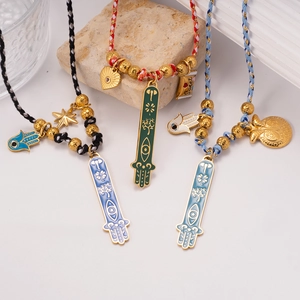 Handwoven Hamsa Hand and Evil Eye charm necklaces with gold beads on natural stones