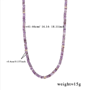 Détail macro du collier de perles d'améthyste violette avec espaceurs dorés fins