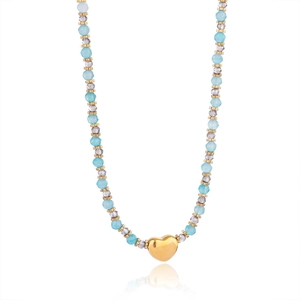 Vue macro du collier de perles bleues avec un pendentif cœur doré poli et perles en métal