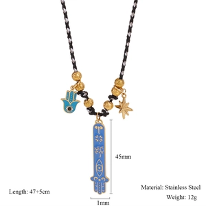 Detailed view of Hand of Fatima pendant and Evil Eye charm on hand-woven necklace