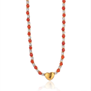 Détail de perles facettées et d'un pendentif cœur sur un collier de style vintage