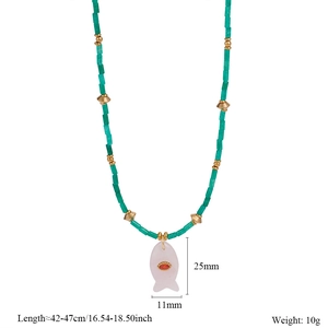 Macro detail of turquoise beads and a pink fish pendant with size measurements