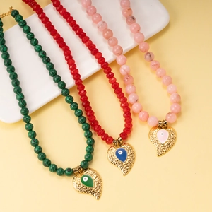 Detailed shot of beaded necklaces with malachite beads and textured heart evil eye charms