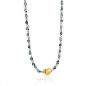 Détail de perles colorées avec pendentif cœur doré sur un collier vintage