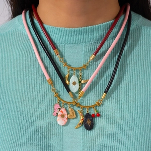 Collana a tre strati in pelle con ciondoli a ippocampo, ciliegia e cuore su modella