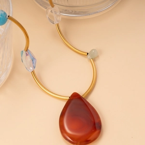 Collier avec monture dorée, perles colorées et pendentif en agate rouge goutte
