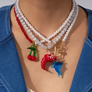 Three-layer ocean-style necklace with cat's eye stone, cherry, lobster, and dolphin charms