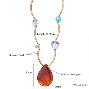 Détail du grand pendentif en agate rouge avec une chaîne à perles en acier inoxydable doré