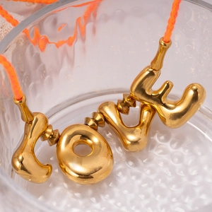 Collana con ciondolo LOVE dorato e corda intrecciata arancione su sfondo di vetro