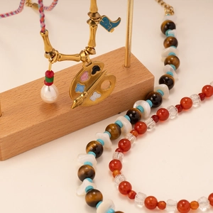 Bohemian tiger eye necklace and red agate beaded jewelry set on a brass display stand