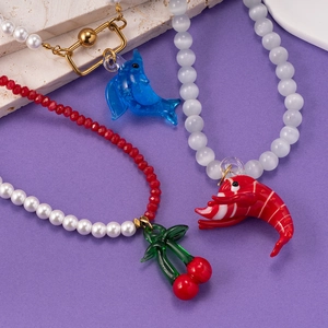 Necklace with cat eye stone featuring dolphin, lobster and cherry glass charms