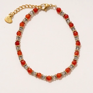 Détail d'un bracelet en perles avec pendentif en cœur doré et fermoir mousqueton