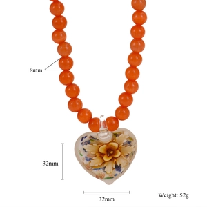 Vue détaillée du collier de perles orange avec un pendentif cœur en verre de 32mm