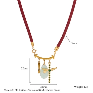 Dettaglio della collana in corda con croce dorata, ciondolo a scarpa e pietra naturale
