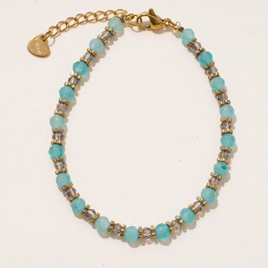 Détail de perles de pierre facettées colorées et pendentif cœur doré sur collier