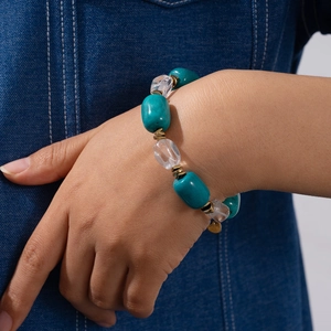 Bohemian beaded bracelet with turquoise and clear crystal stones on a denim background
